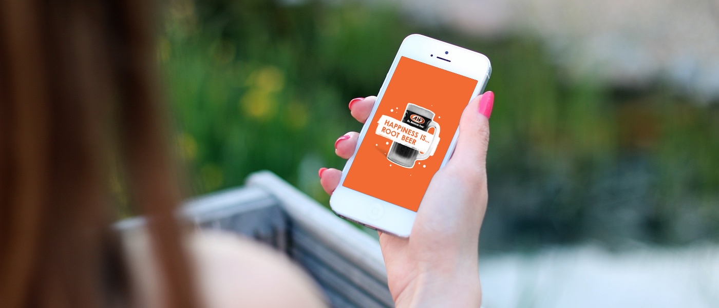 Girl holding phone in hand with 'Happiness is Root Beer' phone wallpaper